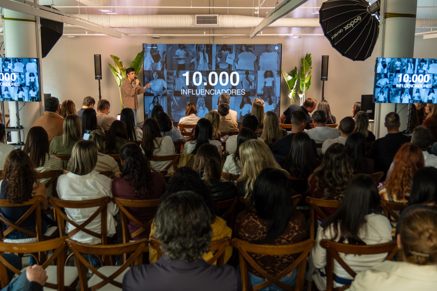 Sala cheia com painel de LED, TVs e caixas de som
